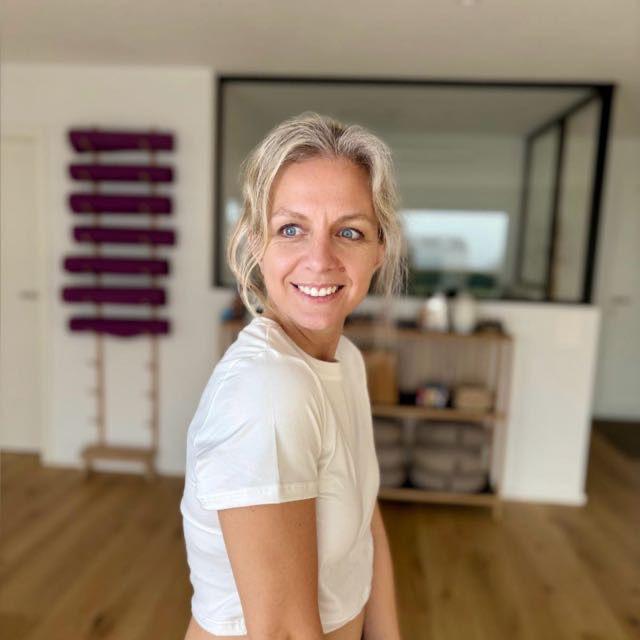 Neira, yogathérapeute, souriante dans son espace de pratique